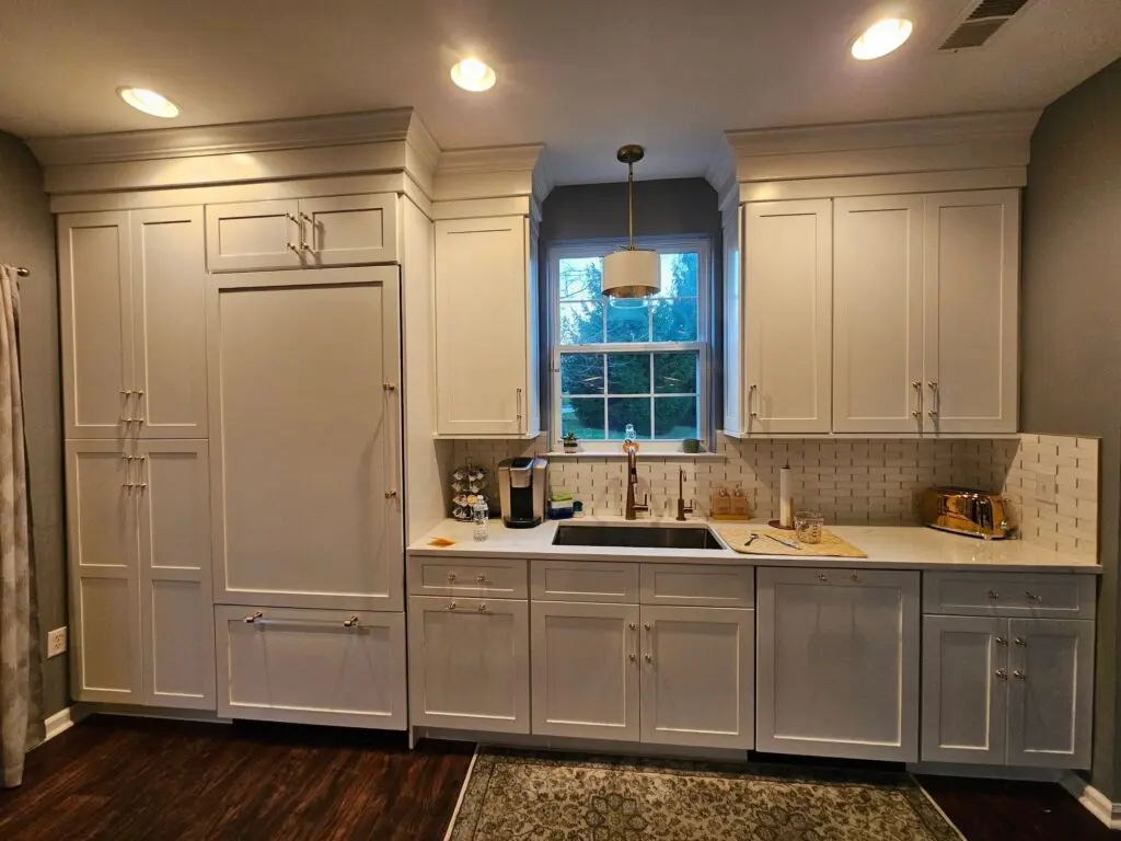 A kitchen with white cabinets and a sink.