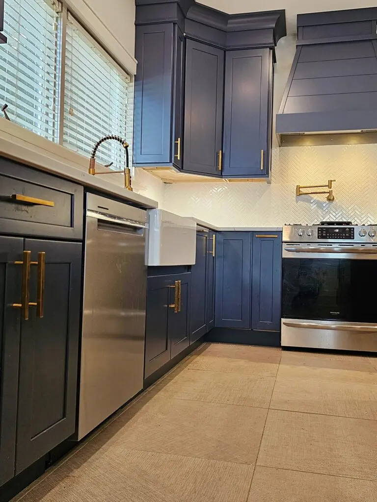 A kitchen with blue cabinets and stainless steel appliances.