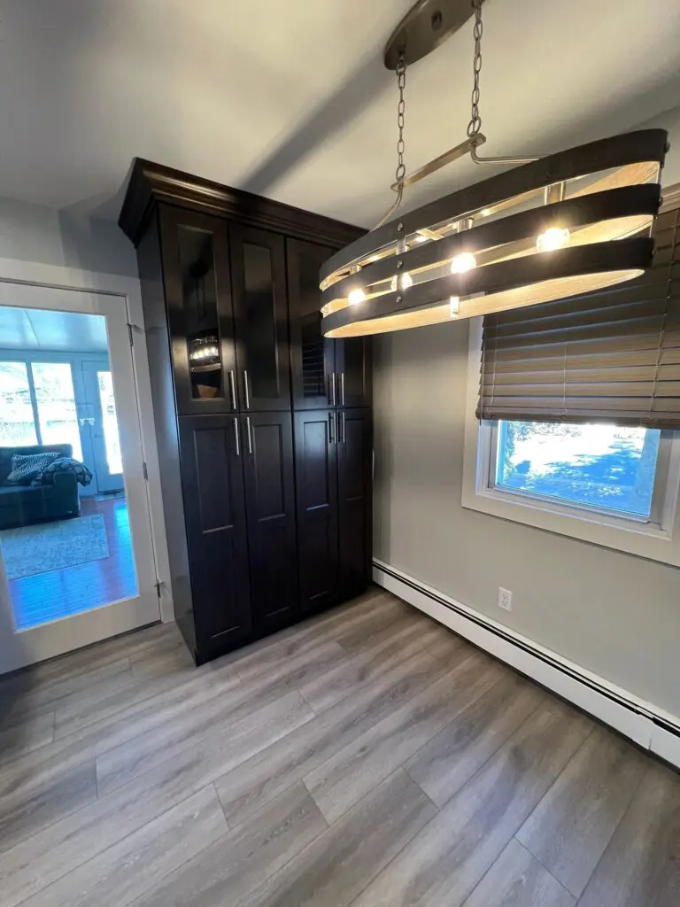 A room with a large black cabinet and wooden floors