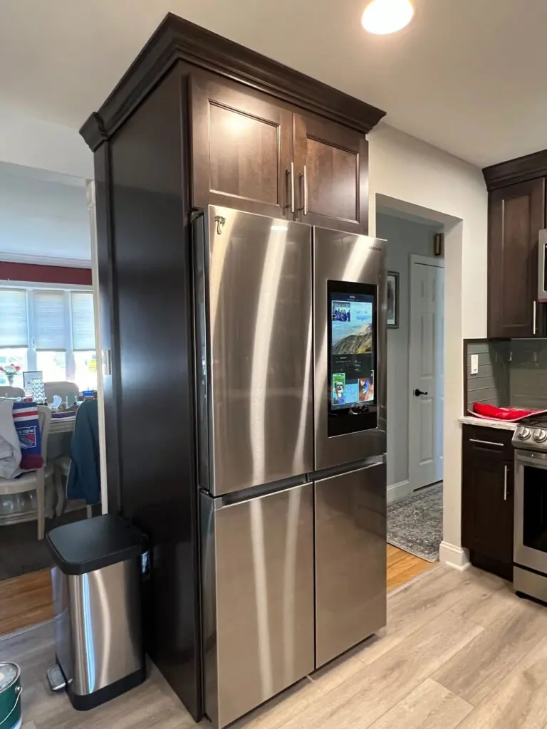 A stainless steel refrigerator in the middle of a kitchen.