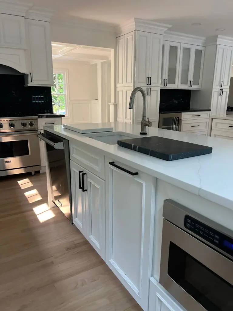 A kitchen with white cabinets and black appliances.