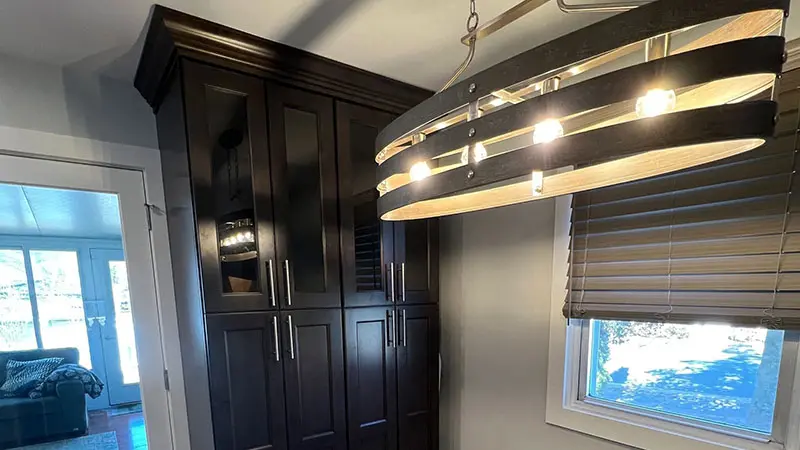 A large closet with dark wood cabinets and a light fixture.