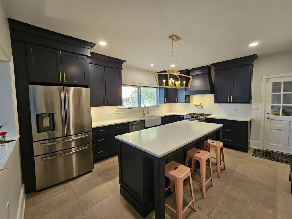 A kitchen with black cabinets and white counter tops.